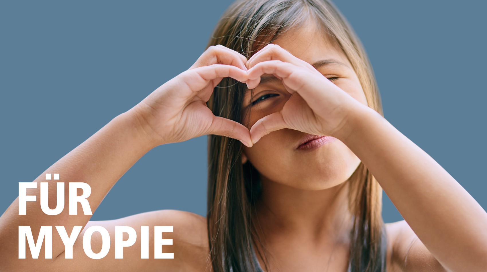 Für Myopie: Mädchen zeigt mit den Händen ein Herz.